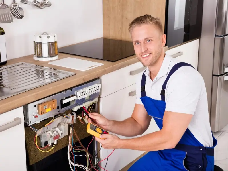 Fixton technician opening an appliance control panel during an in-home repair in London, Ontario